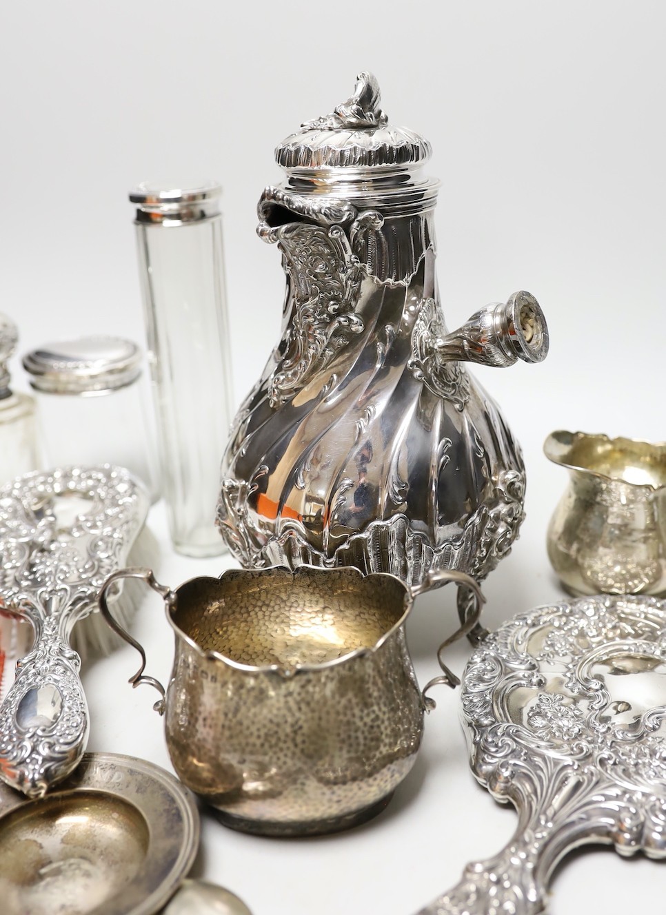 A late 19th/early 20th century French white metal coffee or chocolate pot (lacking handle), gross 21.5oz, a silver cream jug and sugar bowl, five French white metal mounted toilet jars, three silver napkin rings, a silve